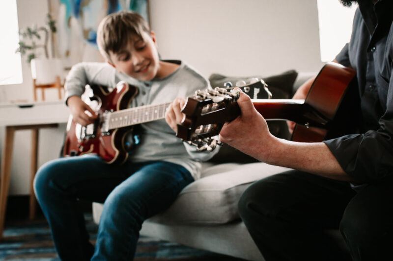 teacher playing guitar with students