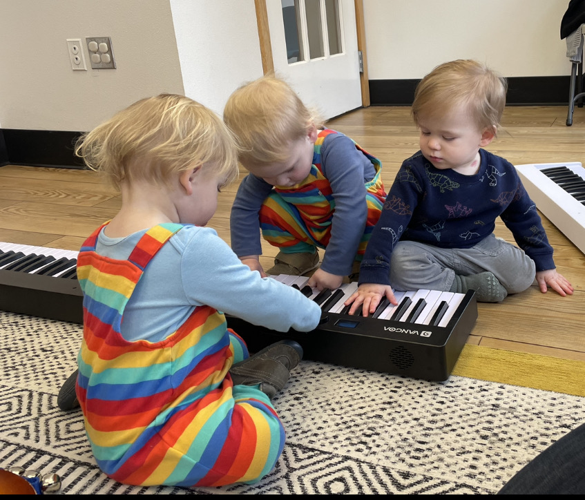 three children around a piano